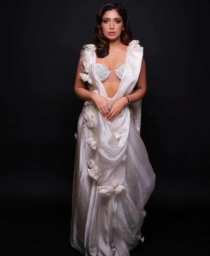 Bhumi Pednekar exudes pure sophistication in an all-white ensemble that captures attention. The glittery blouse, adorned with intricate netting in the middle, strikes a perfect balance between glamour and subtlety.